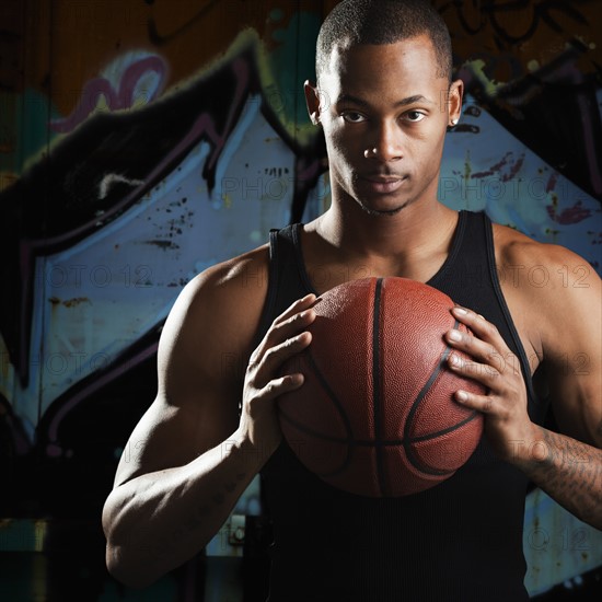 Portrait of young man with basketball. Photo : Mike Kemp