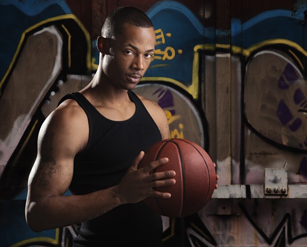 Portrait of young man with basketball. Photo : Mike Kemp