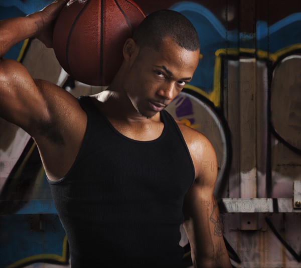 Portrait of young man with basketball. Photo : Mike Kemp