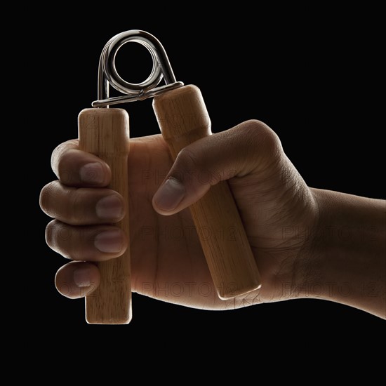 Studio shot of young man's hand exercising. Photo : Mike Kemp