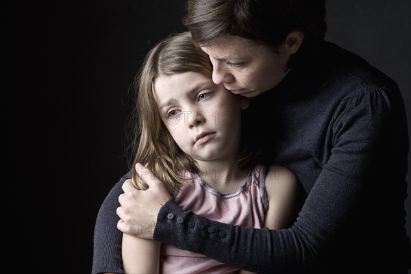 Mother and daughter (6-7) embracing. Photo : Justin Paget