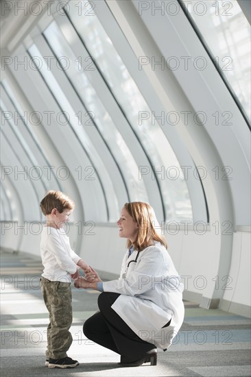 Female doctor talking to boy (6-7) in corridor. Photo: Mark Edward Atkinson