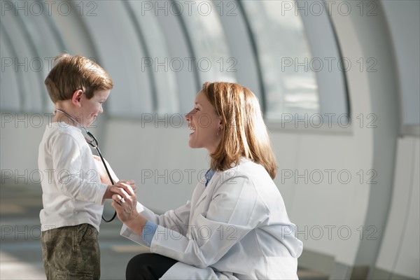 Female doctor talking to boy (6-7) in corridor. Photo : Mark Edward Atkinson