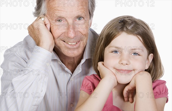 Studio portrait of senior man with granddaughter (6-7). Photo: Justin Paget