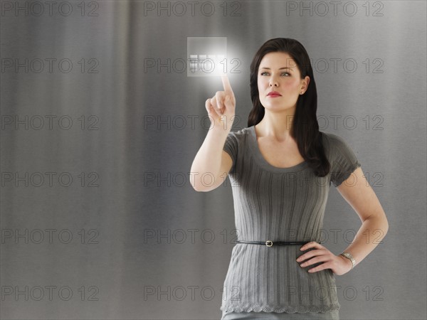 Young businesswoman using digital keypad.