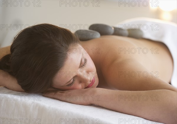 Woman receiving hot stone therapy.