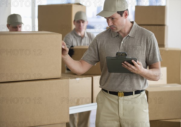 Man checking checklist in warehouse.