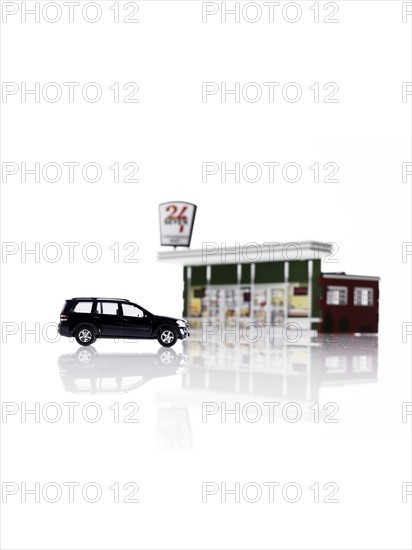 Toy car in front of toy gas station. Photo : David Arky