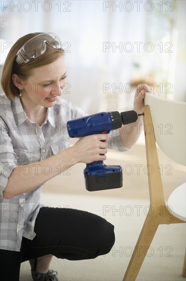 Woman repairing chair.