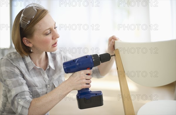 Woman repairing chair.