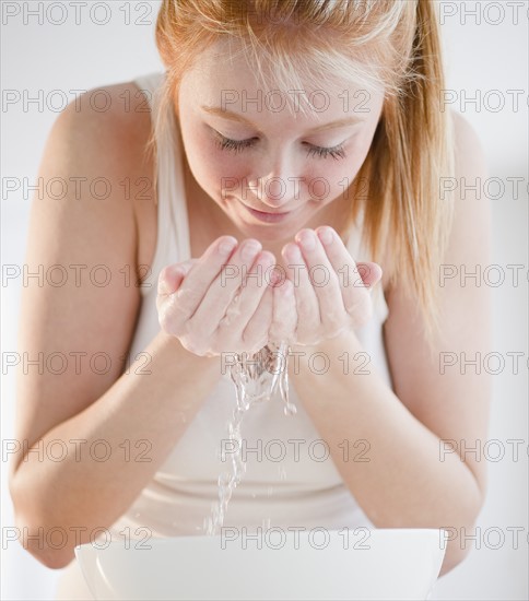 Woman washing face. Photo : Jamie Grill Photography