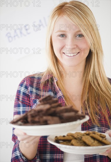 Woman holding plates full of cakes. Photo : Jamie Grill Photography
