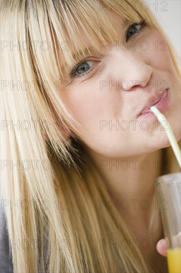 Young woman drinking juice. Photo : Jamie Grill Photography