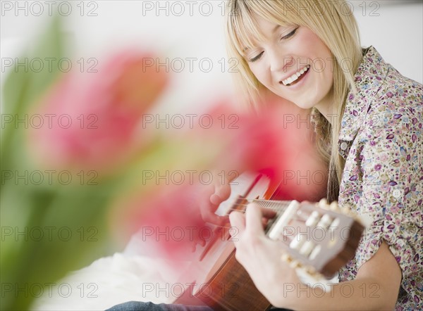 Young woman playing guitar. Photo: Jamie Grill Photography