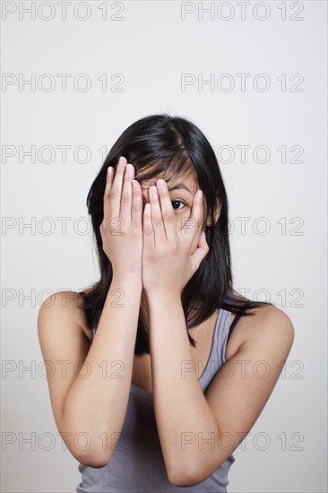 Young woman covering eyes with hands. Photo : Winslow Productions