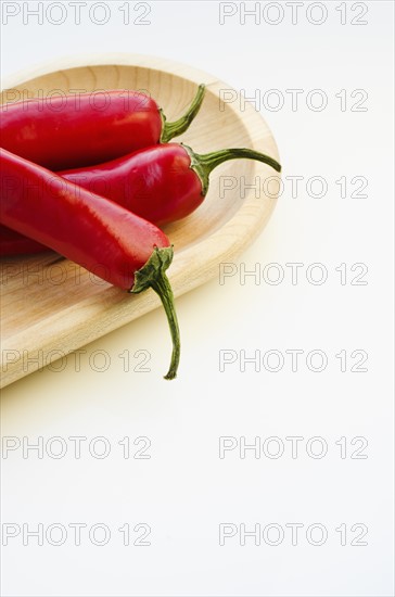 Close up of chili peppers on wooden tray.