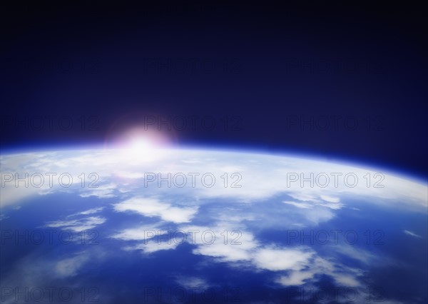 Space with rising sun above planet earth.