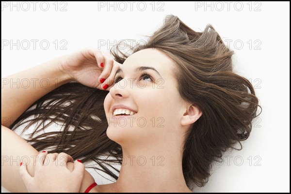 Young woman lying down, smiling. Photo: Mike Kemp