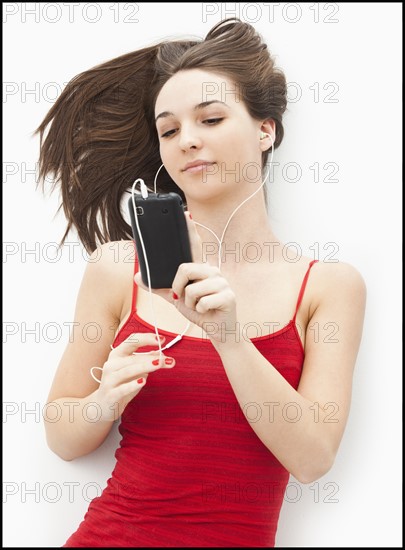 Young woman listening to mp3 player. Photo : Mike Kemp