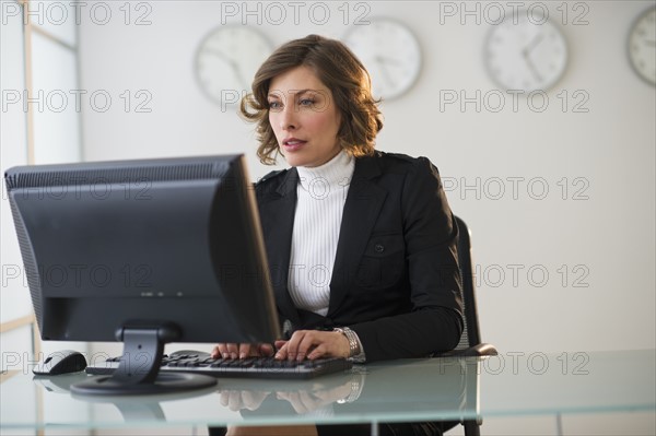 Businesswoman working at desk in office.