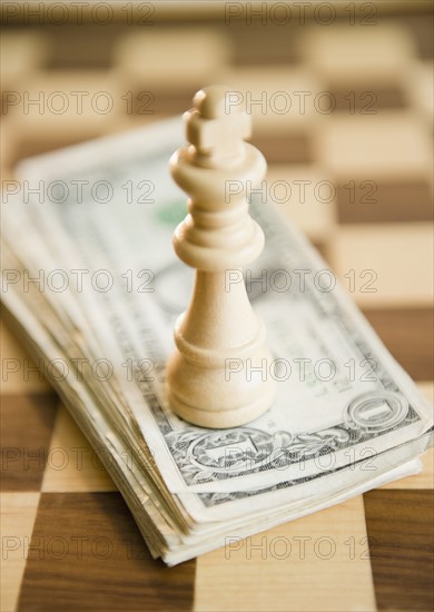 Studio shot of king chess piece on banknotes. Photo: Jamie Grill Photography