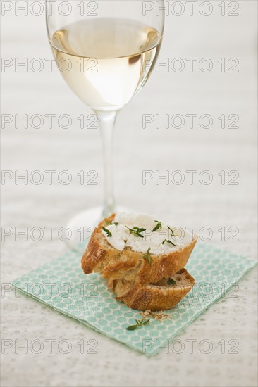 Studio shot of small sandwich and glass of white wine.