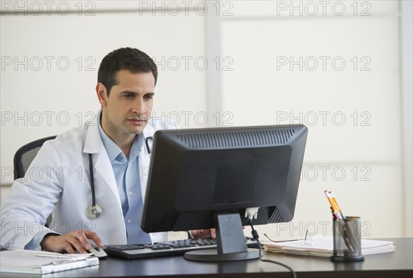 Doctor using computer in office.