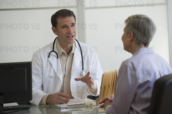 Doctor and female patient sitting in office.