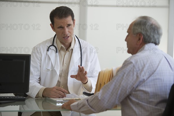 Doctor and female patient sitting in office.