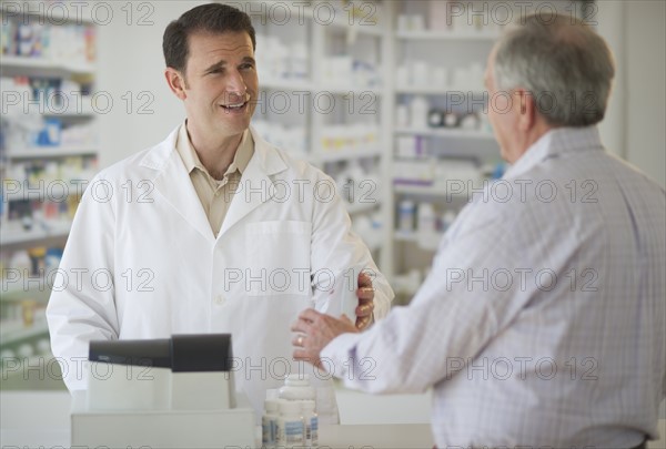 Pharmacist explaining use of medicine to patient.