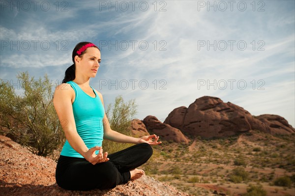 USA, Arizona, Phoenix, Young woman practicing yoga on desert.