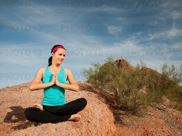 USA, Arizona, Phoenix, Young woman practicing yoga on desert.