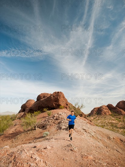 USA, Arizona, Phoenix, Mid adult man jogging on desert.