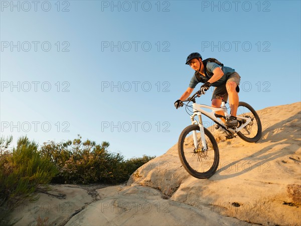 USA, California, Laguna Beach, Man cycling down hill.