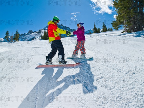 USA, Colorado, Telluride, Father and daughter (10-11) snowboarding . Photo : db2stock