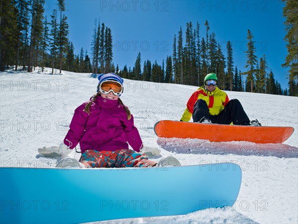 USA, Colorado, Telluride, Father and daughter (10-11) posing with snowboards in winter scenery. Photo : db2stock