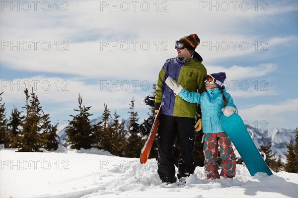 USA, Colorado, Telluride, Father and daughter (10-11) standing with snowboards in winter scenery. Photo : db2stock
