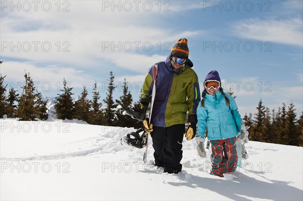 USA, Colorado, Telluride, Father and daughter (10-11) posing with snowboards in winter scenery. Photo : db2stock