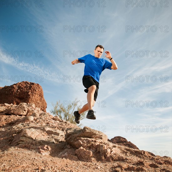 USA, Arizona, Phoenix, Mid adult man jogging on desert.