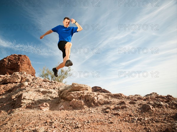 USA, Arizona, Phoenix, Mid adult man jogging on desert.