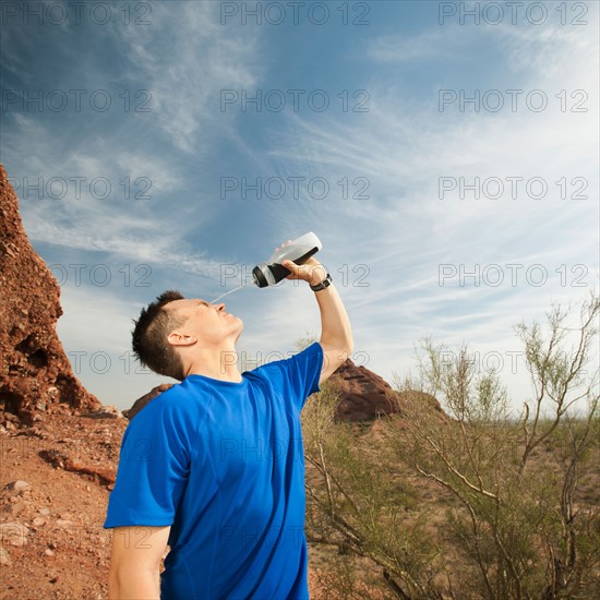 USA, Arizona, Phoenix, Man pouring water on his face.