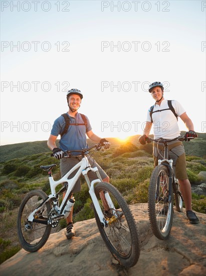 USA, California, Laguna Beach, Two bikers on hill doing fist bump.