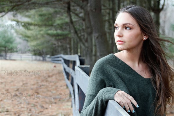 USA, New Jersey, Califon, Teenage girl (16-17) standing near fence and looking away, portrait. Photo : Pauline St.Denis