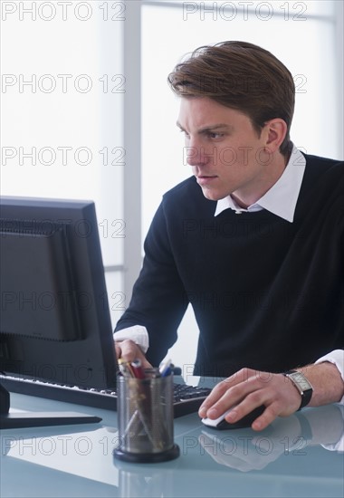 Man working on computer at office. Photo : Daniel Grill