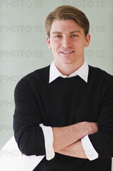 portrait of young teacher standing in front of blackboard. Photo : Daniel Grill