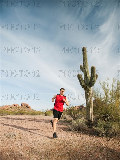 USA, Arizona, Phoenix, Mid adult man jogging on desert.