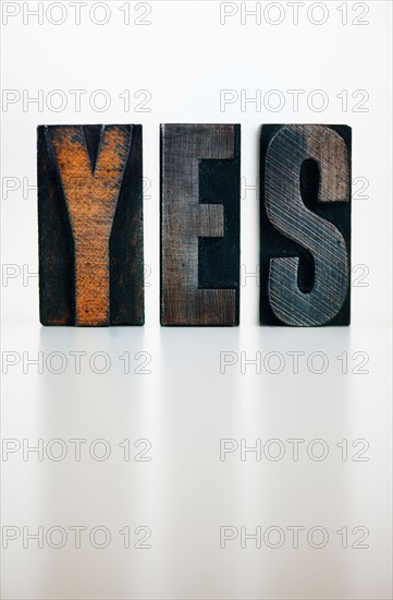 Wooden letter blocks spelling 'yes' studio shot.