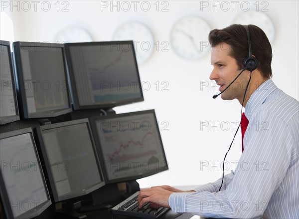 Financial worker analyzing data displayed on computer screen.