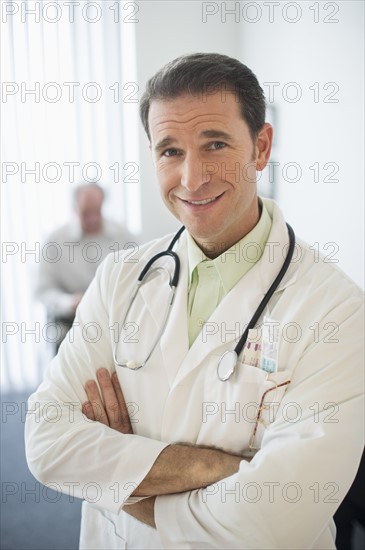 Portrait of doctor, senior couple in the background.