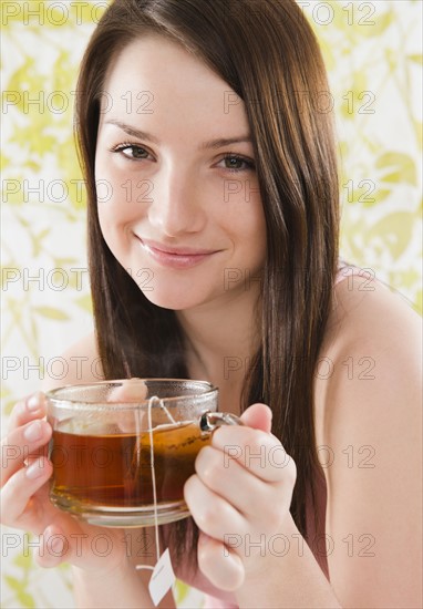 Portrait of smiling young woman holding tea cup. Photo : Jamie Grill Photography